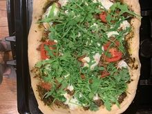Sausage, tomato, mozzarella and arugula pizza.  