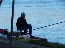 A fisherman on the river in Seville.  He used a slingshot to send his bait into the water.