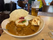 Ed's dinner - Caribbean chicken with curry, naan, rice, and pickled onion.