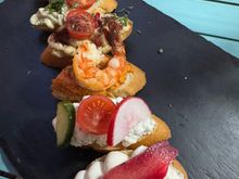 Our delicious appetizer - bruschetta with various toppings, such as cheese, humus, pate, and shrimp