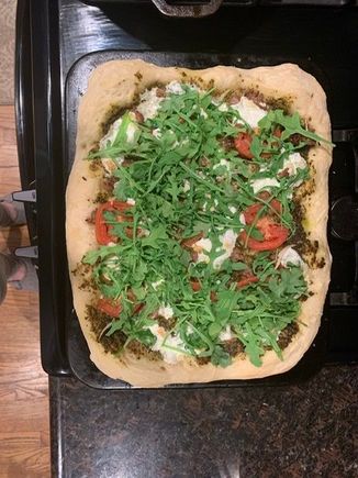 Sausage, tomato, mozzarella and arugula pizza.  