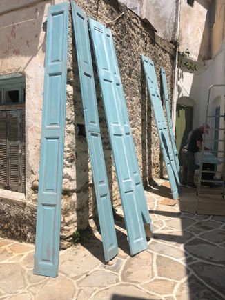 Man painting his shutters - pretty shade of blue