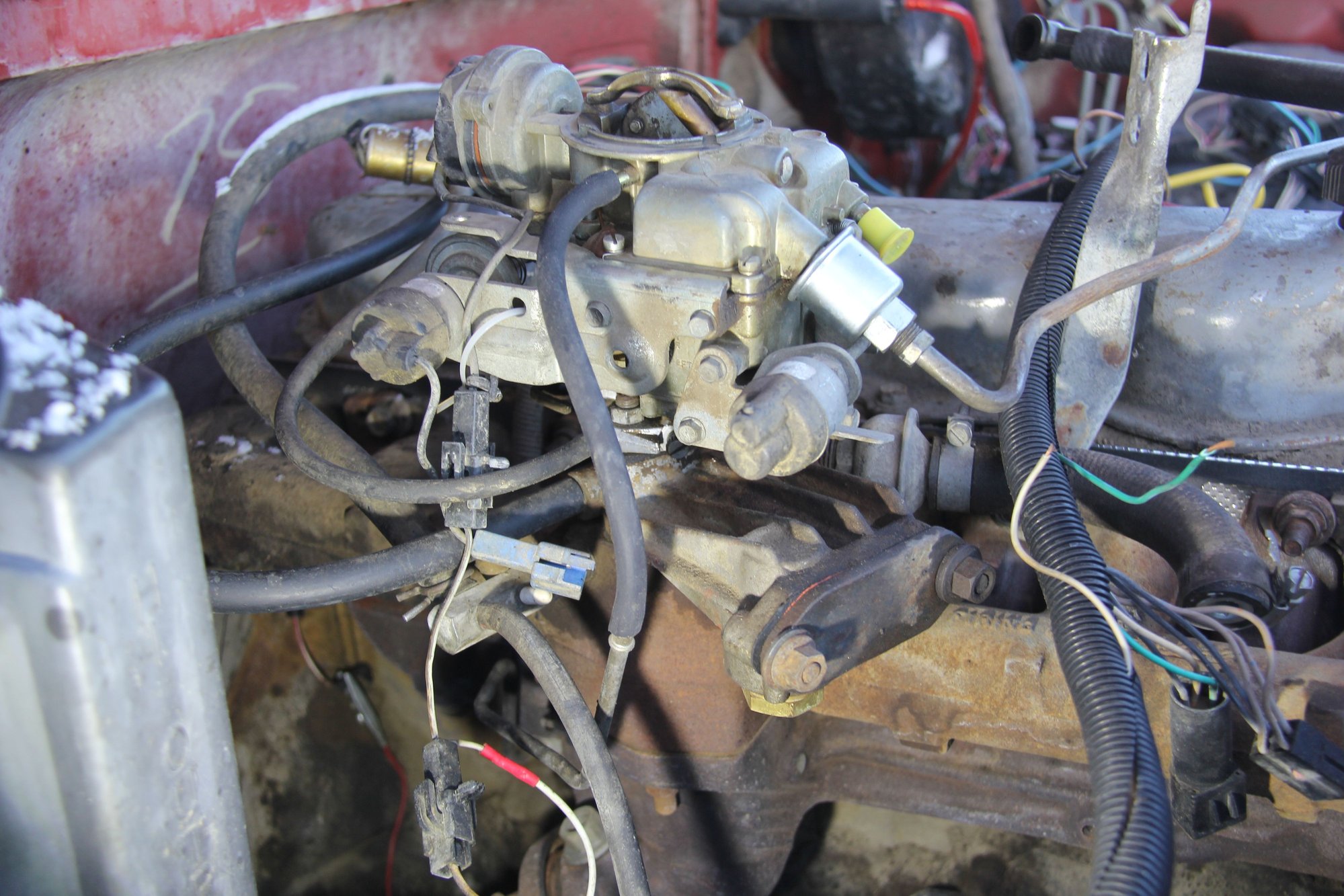  the right  side  of  the  carb.  the  black  hose  pointing  down  goes  to  the  MAP..    the  wire  that  goes  up  to  the  carb   (held  in  place  with a  zip  tie )  is  also  from  the  MAP  and  I  don`t  know  if  it  is  attached  to  the  carb. or  not