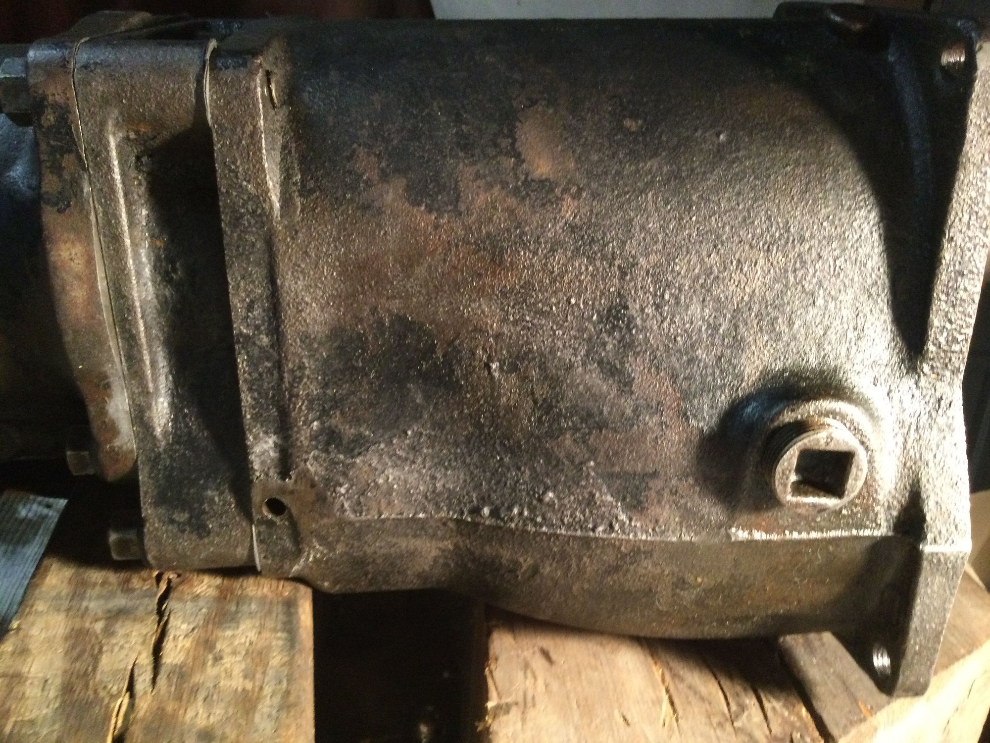 This is the bottom side of the transmission. Use a pin punch and drive the pin up and out. Side cover must be off.