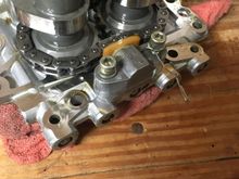 A back shot of the cam plate. Two more Allen heads secure the tensioner. Remove these, then the snap ring on the front cam shaft. The snap ring is located on the front side of the plate, once removed, both cams, spacers, and chain will slide right out. I chose to reinstall the cam chains the facing the same way as they were before removal.