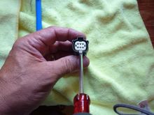 using a small flat blade screw driver pop the plastic insert out about an 1/8".  By doing this you can push the wires forward from behind to take the tension off the pin latches.