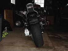 Kuryakyn curved plate mount, HD Tri-bar LED, smoked rear turn signal lens with red light bulbs.