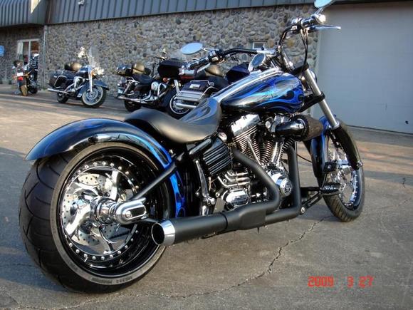 RIGHT SIDE
H-D 103" w/ Low-End Cams and Modified Heads
Bassani Road Rage 2-1 Exhaust with Chrome End
Renegade Elite Wheels with HHI Drive-Side Brake
Custom High-End Seat with Flame Inlays
Airea 5150 Paint - Black, Tribal Flames, Airbrushing
H-D Axle Covers w/ Custom made inserts &amp; Skull