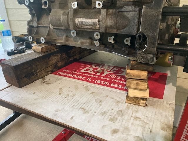 Engine on work bench; wood underneath ensures the weight of the block is not applying pressure on the crankshaft.  