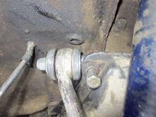 Bolt going through the subframe through the spindle, nut on inner end. Note: the cabin end wishbone does not have to be removed to get out the spindle.