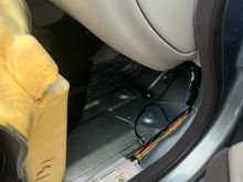 Black flashlight sitting on floorpan