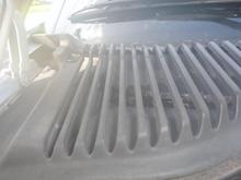 Hard to see, but there are two retaining nuts accessible through the cown vent grill