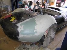 Note that all of the black you see on each fender is raw carbon fiber cloth.  Not really what most would consider suitable for paint!  Also, since we glued the molded fenders on the existing body, the seams had to be completely integrated into the original body and the new shapes had to be contour matched as well.  In other words.LOTS of bondo and more carbon fiber!  So, I started smearing the bondo and broke out the sanding supplies.