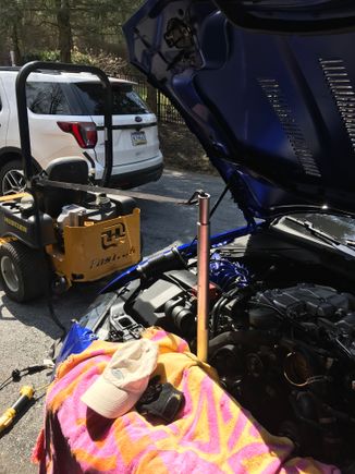 Needed a third hand so I put a jack handle on my ratchet used to release the belt tensioner.  Hooked a ratchet strap to the jack handle and tied the strap off on the family lawn mower!  American ingenuity.
Or redneck engineering??