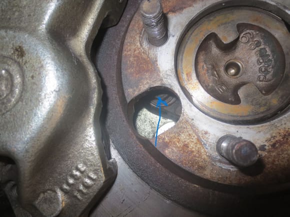 Caliper bolt visible through access hole in disc. ONce the hole is aligned with the bolt it caan be undone 5/8th A/F