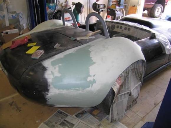 Note that all of the black you see on each fender is raw carbon fiber cloth.  Not really what most would consider suitable for paint!  Also, since we glued the molded fenders on the existing body, the seams had to be completely integrated into the original body and the new shapes had to be contour matched as well.  In other words.LOTS of bondo and more carbon fiber!  So, I started smearing the bondo and broke out the sanding supplies.