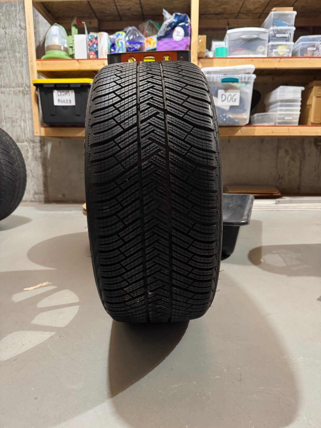 The tire clearly leans to the left (towards the front face of the wheel).