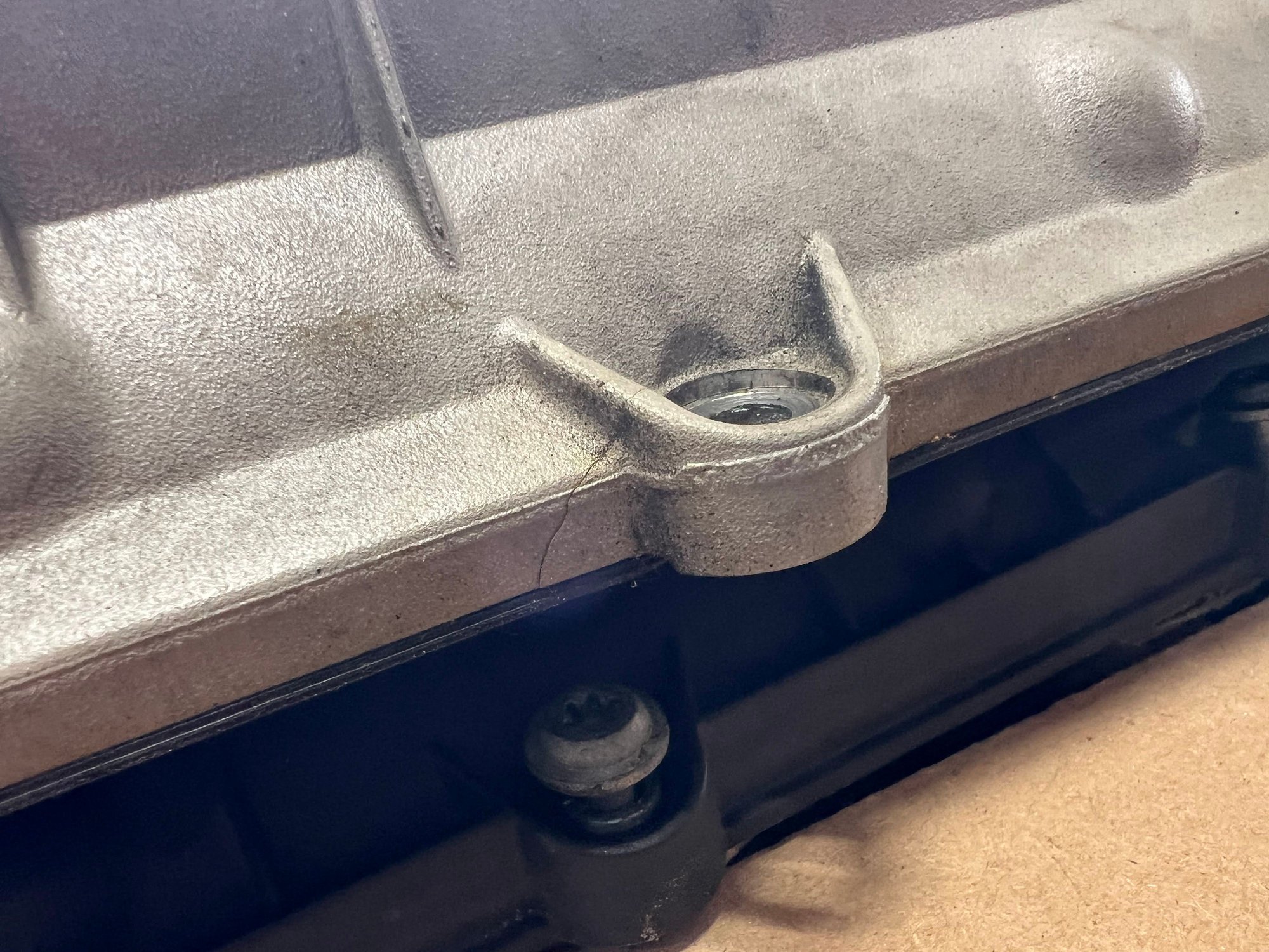 Metal valve cover with hairline crack in it.  
