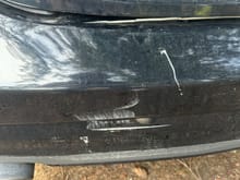 The brunt of the hit. White line under license plate is a huge crack. There is a big gap between the top of the trunk and the bumper that I can stick my fingers thru. Trunk doesn’t seem damaged 