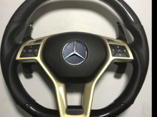 Carbon Fiber gloss finish with double yellow and white chapter ring 'tri ring'
Perforated leather with yellow and white cross stitching.
Gold central  trim piece option
Airbag cover in in alcantara trim option