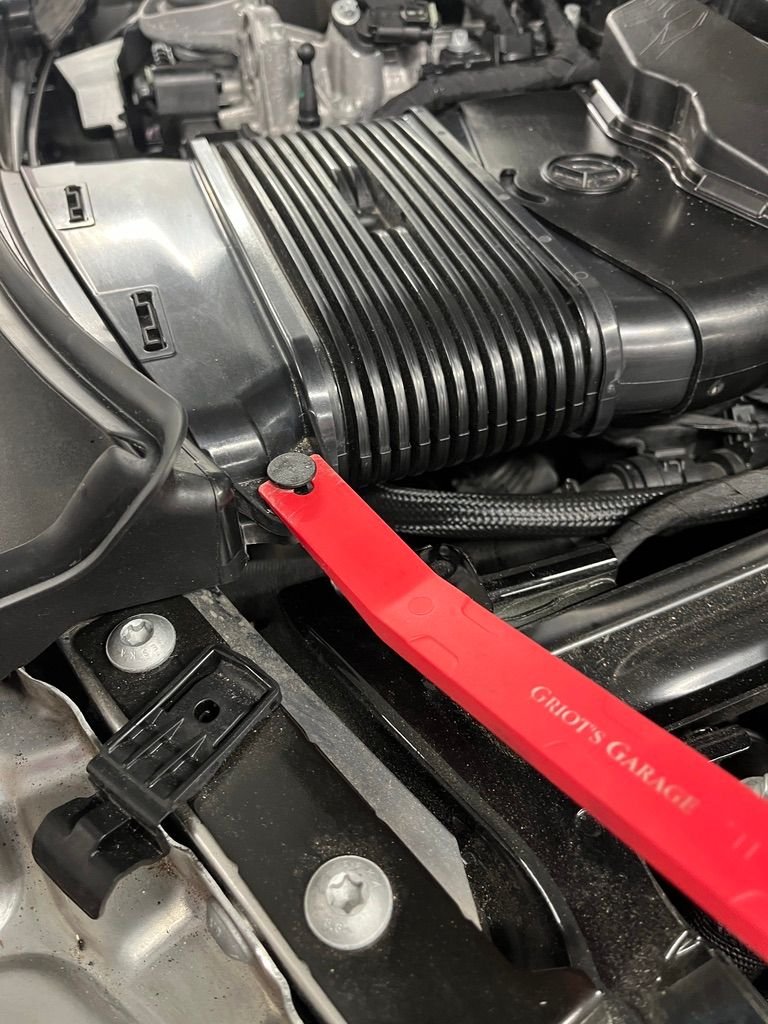 Push pin are front edge of air intake duct.