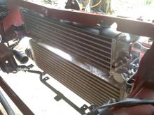 018
an e-bay rx7 oil cooler.  Will need to source out a couple of 16mm x 1.5 straight thread -8 90 degree adapters to make this work.  Still I may have to tip the radiator back some; or merely run the lines out the front side.  Still a work in progress.