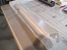 1/2 ounce fiberglass cloth was cut and laid over the flap making sure I has about one inch of overhang all around. 