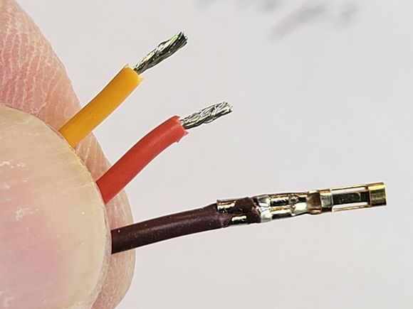 I've stripped off 1/8" insulation off each wire end.  Here's a close up of a properly crimped (male) connector.  Be sure to twist the wire ends before crimping.  Note that there are two crimps, one securing the terminal to the wire insulation and the second to the stripped bare wire.