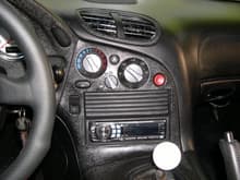 This shows the metalized plastic painted wrinkle finish black and the opening compartment above the radio covered in black leather in the ribbed pattern of the bins.  You can also see the individually chromed louvers in the dash air vent, where the vent surround is also metal painted wrinkle finish black (Picture064)