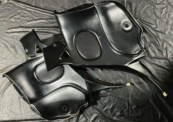 Two RHD panels with belt pass through/strut base cover present but snapped in half.