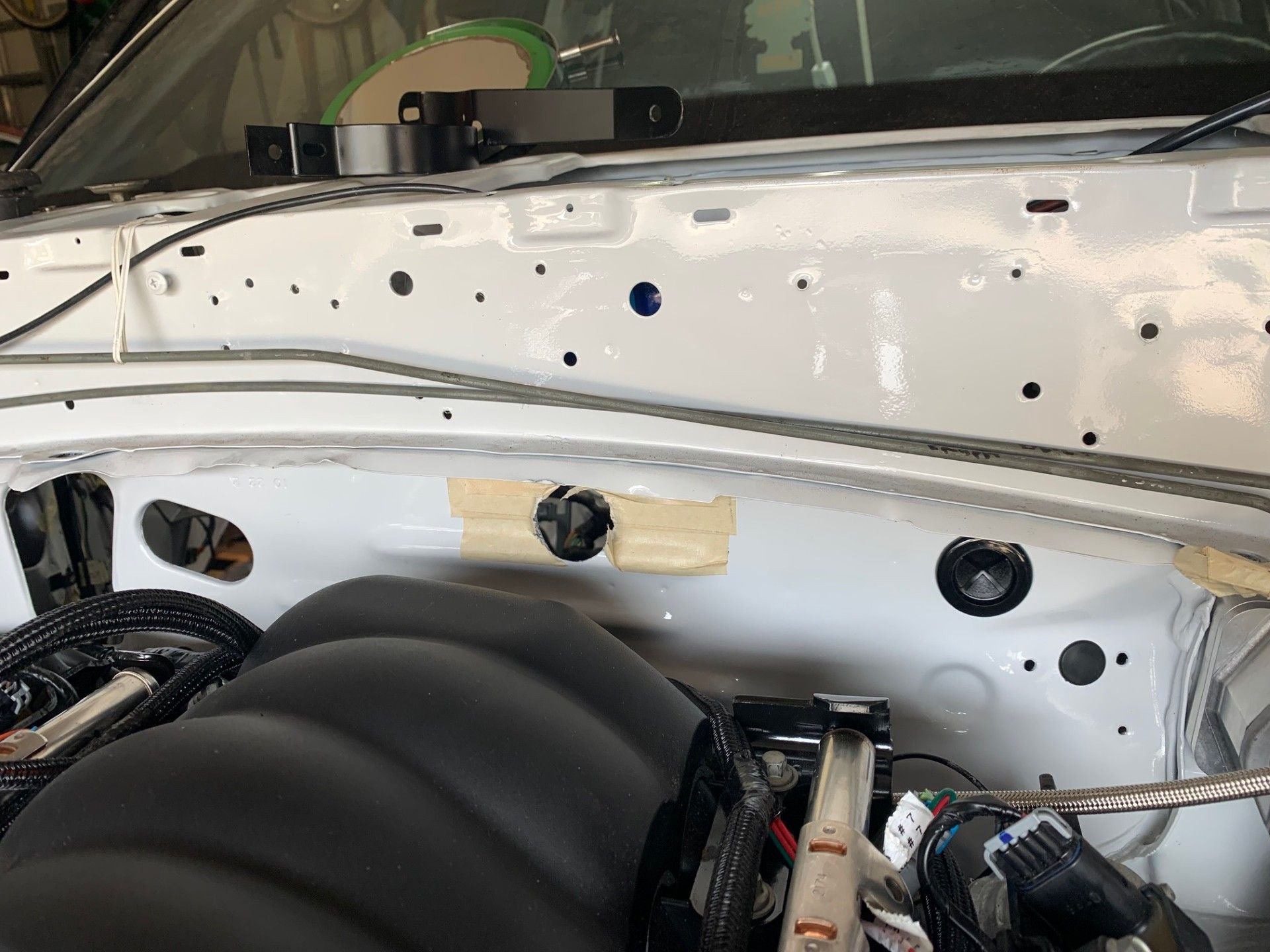 I wanted to use the Ford factory oval hole that you can see on the passenger side of the firewall.  The Holley wire harness was just a little too short to use that oval hole so I had to cut another hole right in the middle of the firewall.