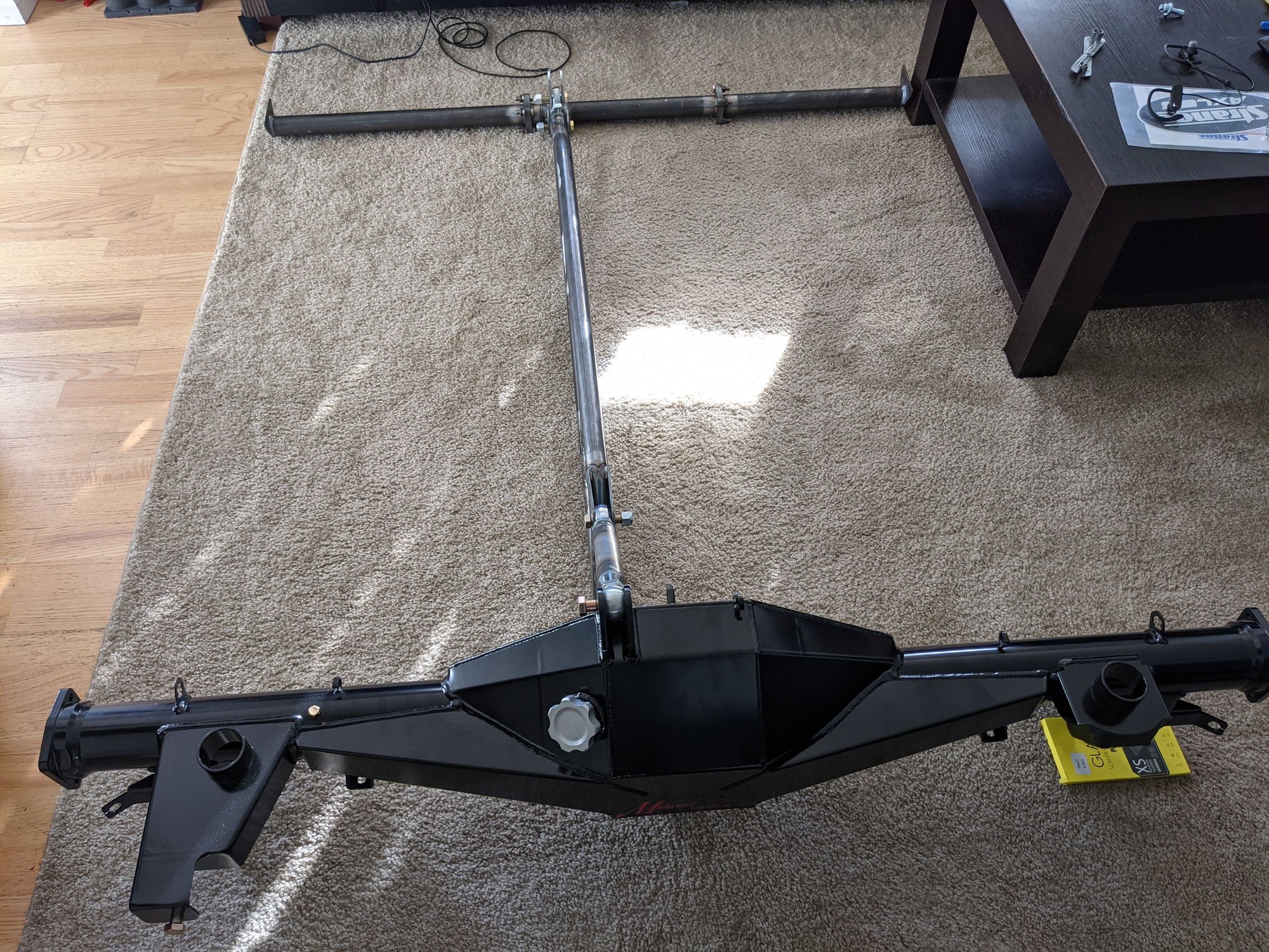 Something like this. The crossmember is welded to the SFC's and is bolted in the center with the front of the TA on a 5 position mount. Midwest calls this a 