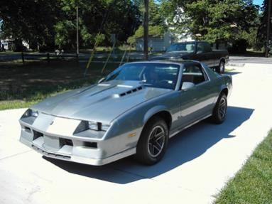 Camaro with stock wheels before hood work and black decals